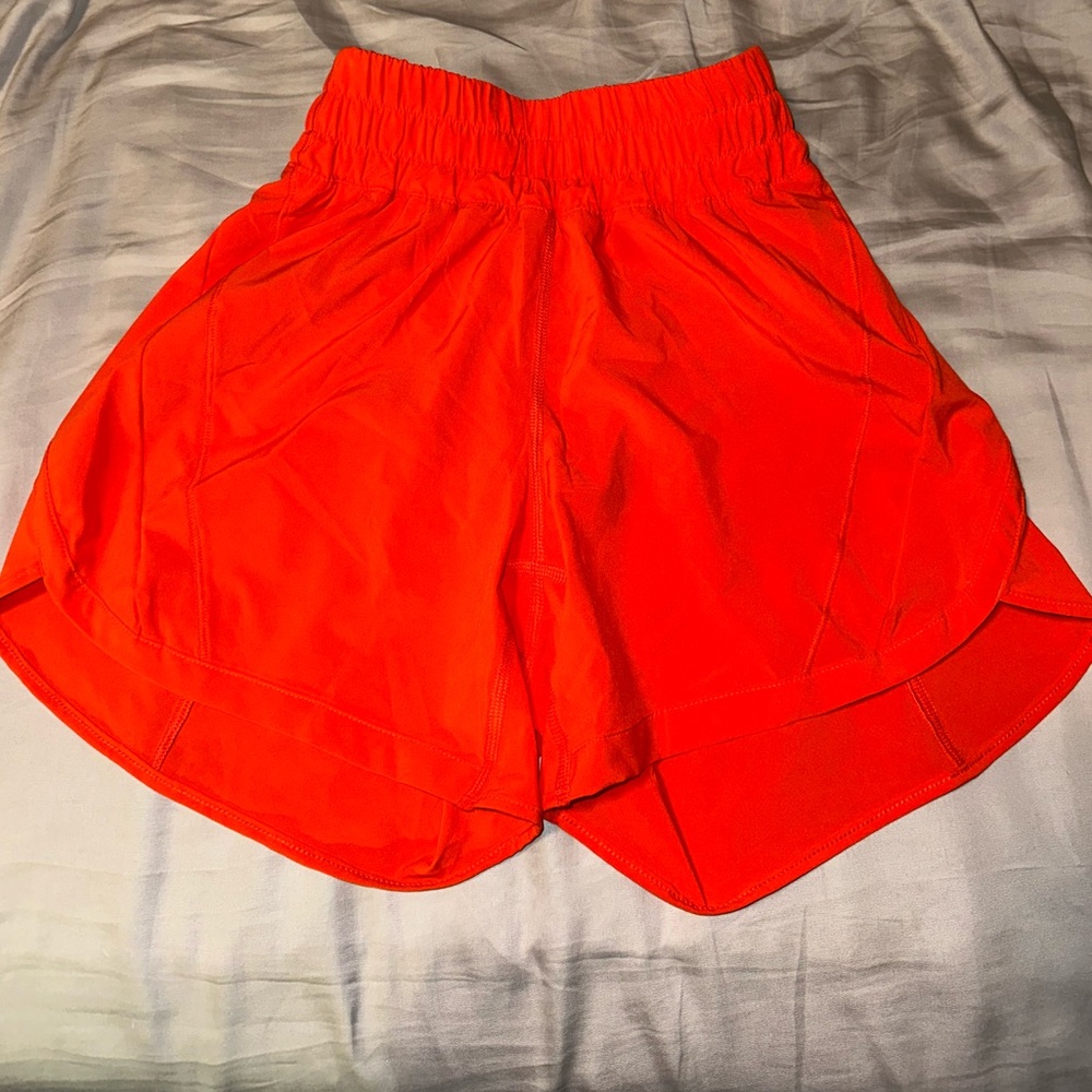 Lululemon track that High-rise 5” short. orange/red in color